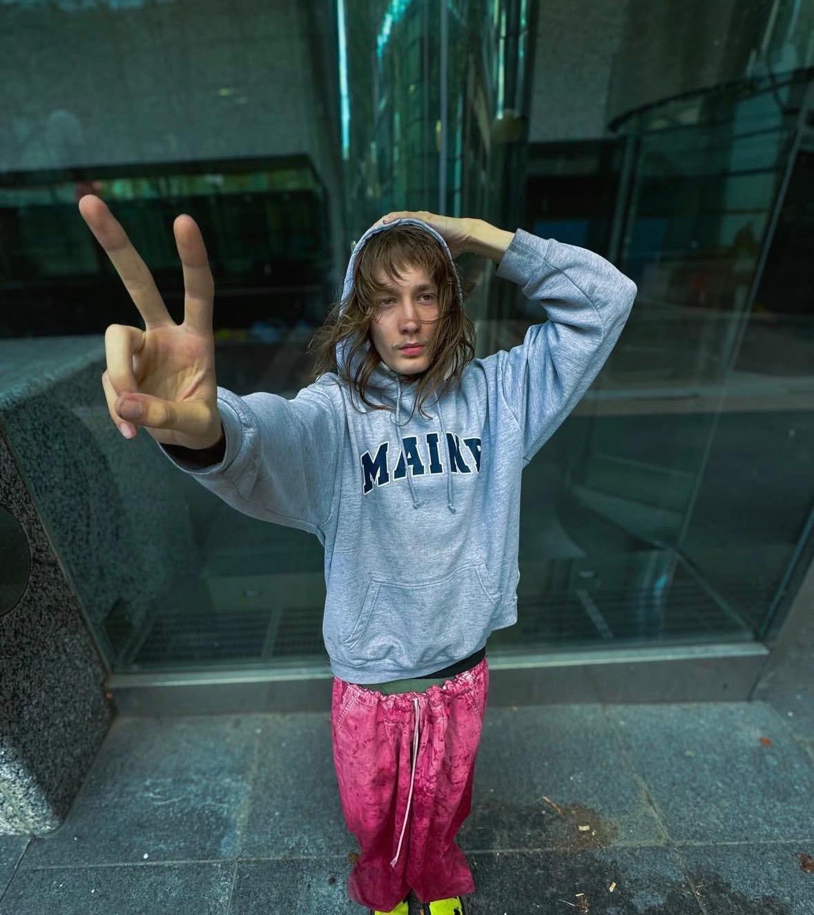 Malkolm throwing up a peace sign, artist, designer, fighter